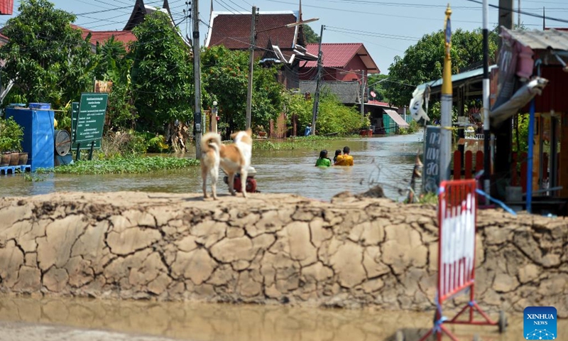 People wade through a flooded street in Ayutthaya, Thailand, on Oct. 18, 2022.(Photo: Xinhua)