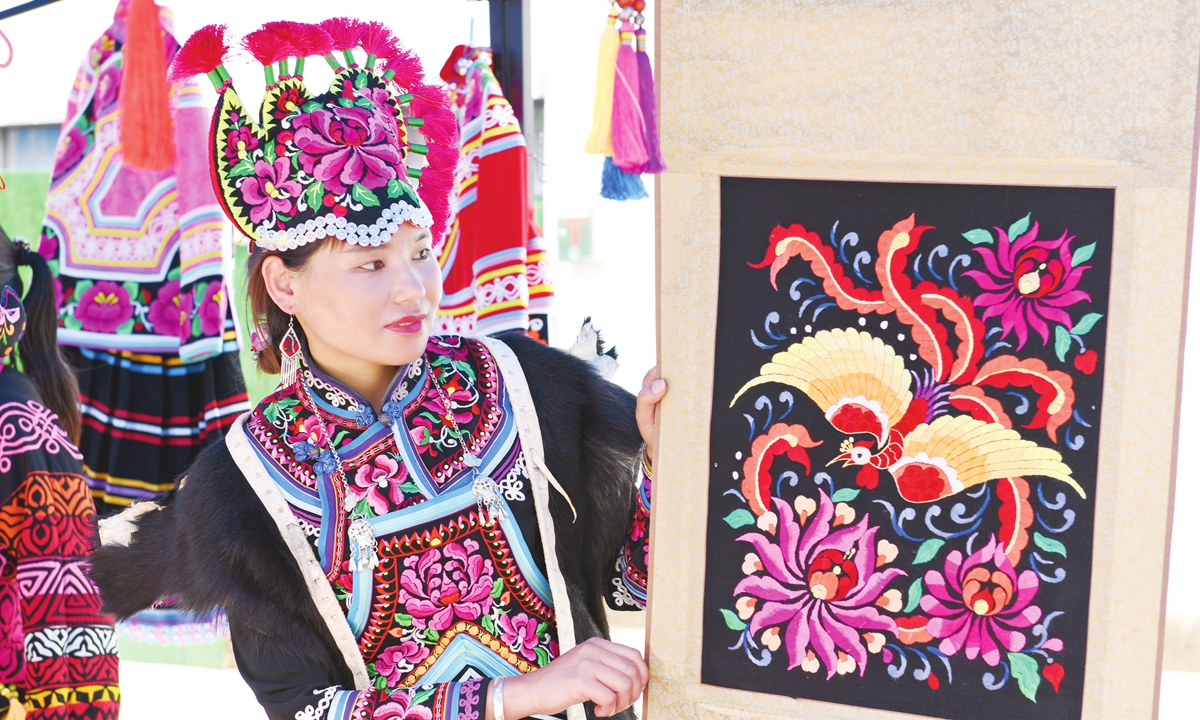 A woman presents the Yi ethnic group's handmade embroidery in Southwest China's Yunnan Province on June 22, 2022. Photo: IC
