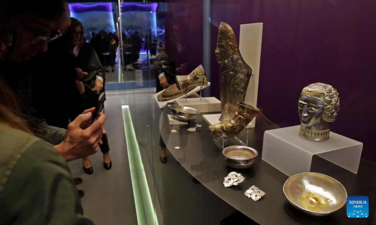 A visitor takes pictures of exhibits of the 