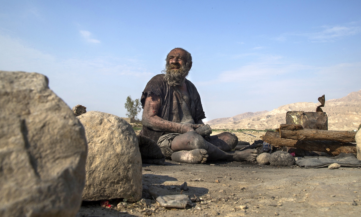 Amou Haji sits on the ground on the outskirts of the village of Dezhgah in the Dehram district of the southwestern Iranian Fars province, on December 28, 2018.Photo: AFP