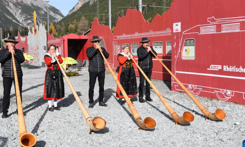 Local people play the traditional Swiss Alphorn to celebrate the Guinness Book of Records' entry of the world's longest narrow gauge passenger train of Swiss Rhaetian Railway in Albula, Switzerland, Oct. 29, 2022. Photo: Xinhua