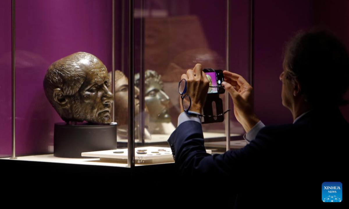 A visitor takes pictures of exhibits of the 