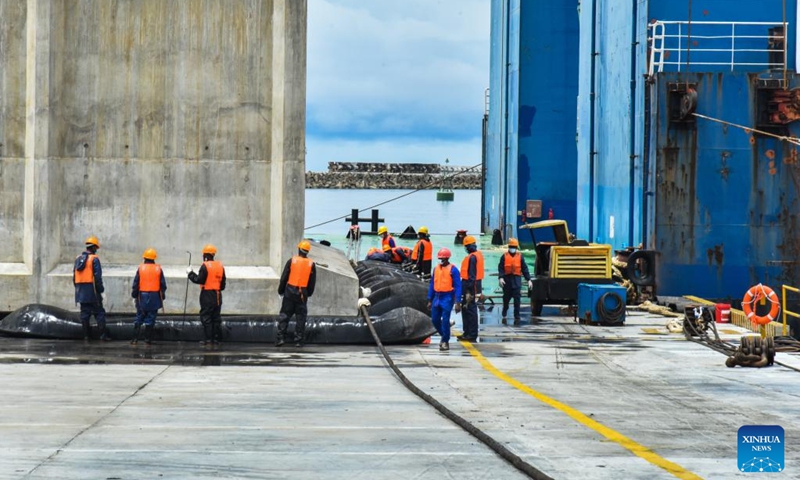 This photo taken on Oct. 22, 2022 shows technicians working to install the first caisson of phase II construction of the Kribi Deep Seaport in Kribi, Cameroon. China Harbour Engineering Company Ltd. (CHEC) has started construction work on the second phase of the Kribi Deep Seaport in southwestern Cameroon with the installation of the first caisson that form the wharves. (Photo by Kepseu/Xinhua)