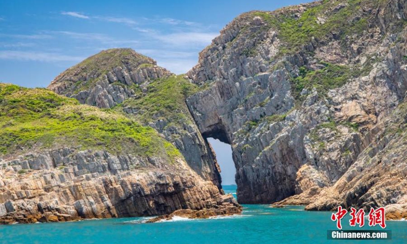 Photo shows the Early Cretaceous rhyolitic columnar rock formation and a sea arch visible on Basalt Island in the Hong Kong Special Administrative Region. (Photo provided to China News Service)
