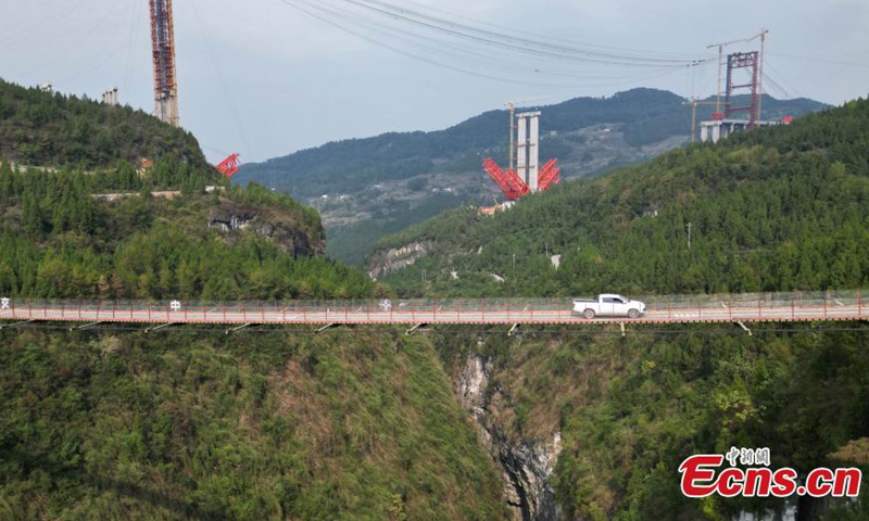 A truck runs on a 300-meter high suspended chain bridge in Wulong, southwest China's Chongqing, Oct. 25, 2022. The bridge is 4.3 meters wide with a main span 245.53 meters and a maximum loading capacity of 45 tons. (Photo: China News Service/Zhou Yi)
