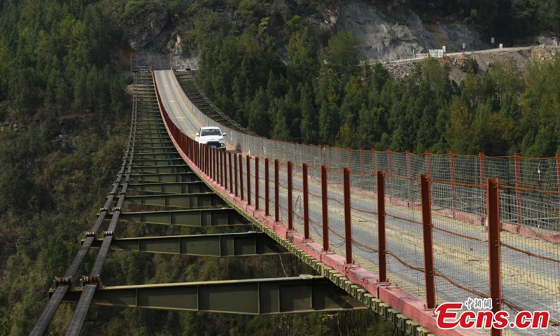 2022年10月25日，一辆卡车在中国西南部重庆市武隆市一座300米高的悬索链桥上行驶。（照片：中新社/周毅）