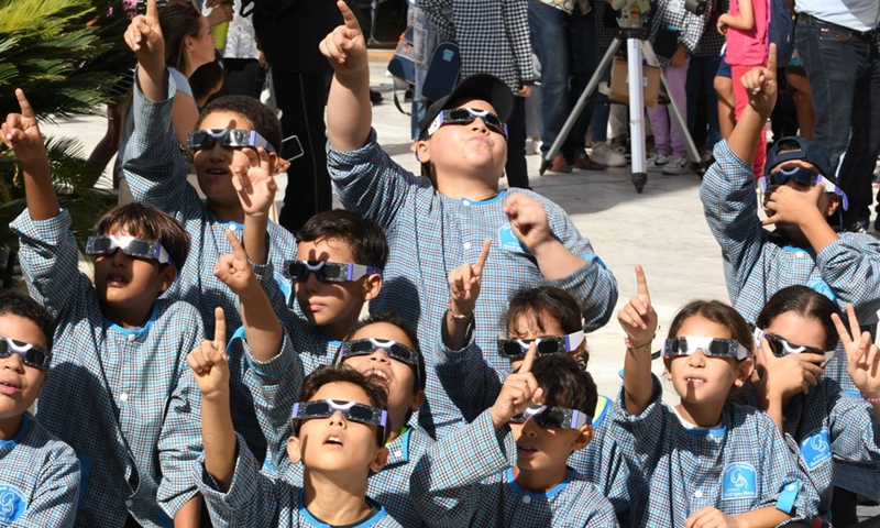 Students observe a partial solar eclipse through solar goggles in Tunis, Tunisia, on Oct. 25, 2022.(Photo: Xinhua)