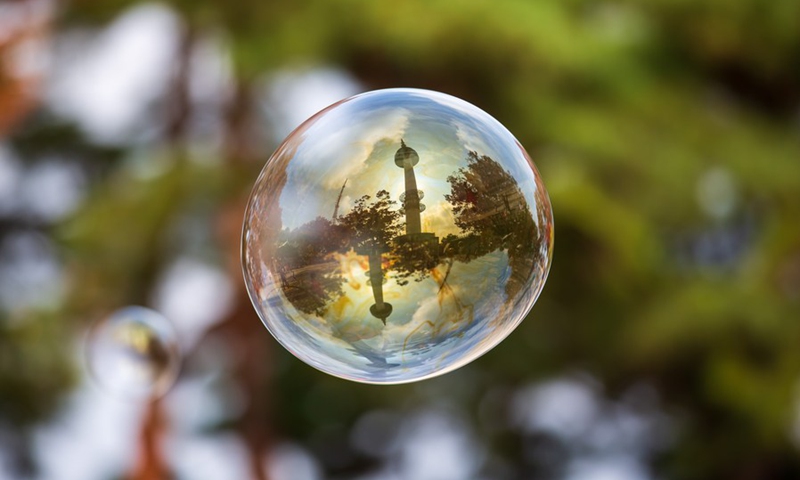 Photo taken on Oct. 23, 2022 shows a soap bubble reflecting the Namsan Seoul Tower at Namsan Park in Seoul, South Korea.(Photo: Xinhua)