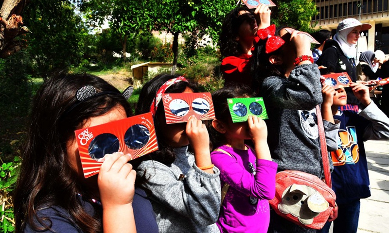 Syrian kids watch the partial solar eclipse witnessed in Damascus, the capital of Syria, on Oct. 25, 2022.(Photo: Xinhua)
