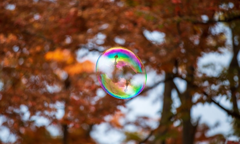 Photo taken on Oct. 23, 2022 shows a soap bubble reflecting the Namsan Seoul Tower at Namsan Park in Seoul, South Korea.(Photo: Xinhua)