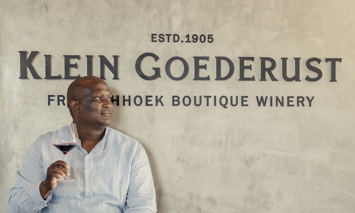 Paul Siguqa, owner of Klein Goederust wine estate, holds a glass of wine as he poses for a portrait at the entrance of his winery in Franschhoek, South Africa on October 14, 2022. Photo: AFP