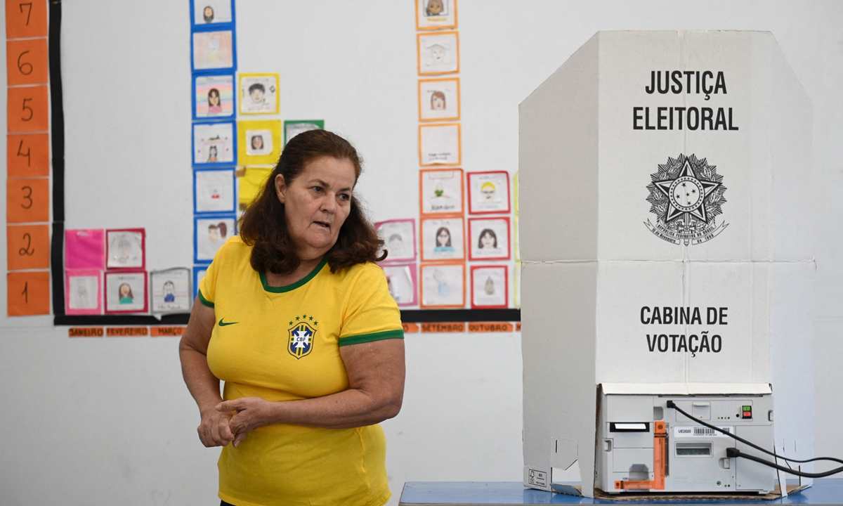 A woman wearing a Brazilian national football team jersey votes at a polling station in Brasilia, on October 30, 2022, during the Brazilian presidential run-off election. The contested runoff pits President Jair Bolsonaro (Liberal Party), who is seeking reelection, against former president Luiz Inacio Lula da Silva (Workers' Party). Photo: VCG