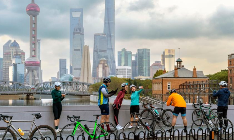 Cyclists take photos by the Suzhou Creek in east China's Shanghai, Nov. 4, 2022. The fifth China International Import Expo (CIIE) is held in Shanghai from Nov. 5 to 10. Photo: Xinhua
