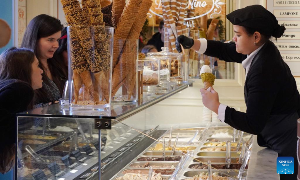 La gente compra il gelato in una gelateria a Roma, Italia, 11 novembre 2022. Il Consiglio Nazionale delle Ricerche d'Italia ha dichiarato martedì che ampie zone del nord Italia quest'anno hanno vissuto l'ottobre più caldo da quando sono iniziate le registrazioni nel 1800. Foto: Xinhua