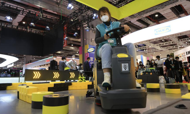 A visitor tries to use a floor cleaner at the China International Import Expo (CIIE) consumer goods exhibition at the National Exhibition and Convention Center (Shanghai), east China's Shanghai, Nov.  6, 2022. Photo: Xinhua