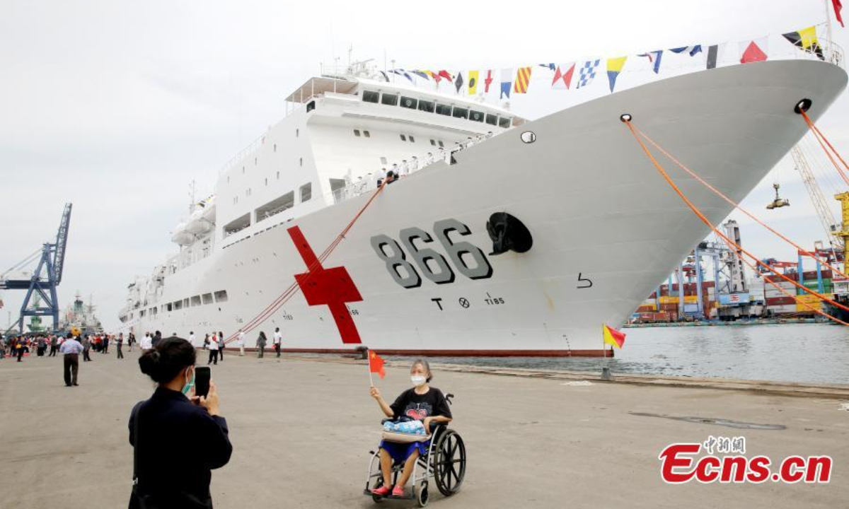 2022年11月10日，当地人欢迎中国人民解放军海军医院船和平方舟抵达印度尼西亚雅加达丹绒普鲁克港。照片：中新社