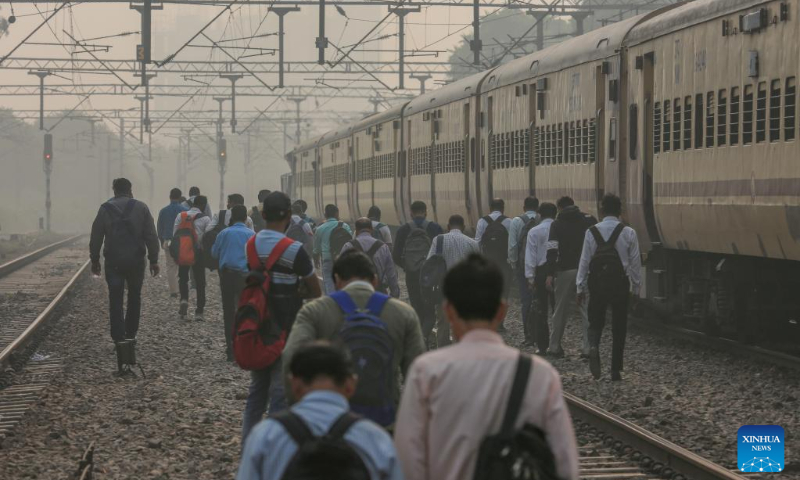People walk on a railway track amid thick smog in New Delhi, India, Nov. 5, 2022. Photo: Xinhua