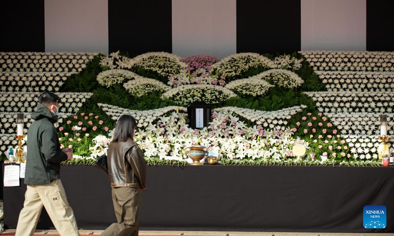 People holding flowers walk to a mourning altar set up at Seoul Plaza in Seoul, South Korea, Nov. 1, 2022. The death toll from a crowd crush, which occurred Saturday night at the Itaewon district of the South Korean capital Seoul during Halloween gatherings, rose overnight, the authorities said Tuesday. At least 156 people were killed and 151 others injured in the incident, according to the Ministry of the Interior and Safety.(Photo: Xinhua)