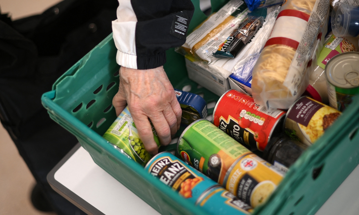 A person looks through food items inside a food bank in Hackney, east London, the UK on October 31, 2022. Photo: AFP
