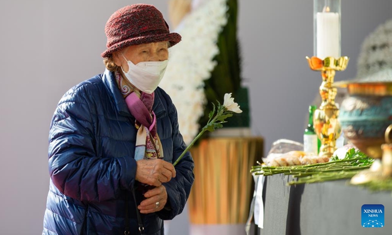 A woman lays a flower to a mourning altar set up at Seoul Plaza in Seoul, South Korea, Nov. 1, 2022. The death toll from a crowd crush, which occurred Saturday night at the Itaewon district of the South Korean capital Seoul during Halloween gatherings, rose overnight, the authorities said Tuesday. At least 156 people were killed and 151 others injured in the incident, according to the Ministry of the Interior and Safety. (Photo: Xinhua)