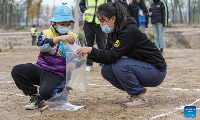 A child practices archaeological excavation work near the Liulihe relic site in Beijing, capital of China, Oct. 30, 2022. Liulihe relic site in Fangshan District of Beijing is believed to be the capital of the Yan kingdom during the Western Zhou Dynasty (1046-771 BC). As part of this year's Beijing Public Archaeology Season, a tour consisting of 20 families is organized to visit the Yan Capital Site Museum of Western Zhou Dynasty and Liulihe relic site on Sunday.(Photo: Xinhua)