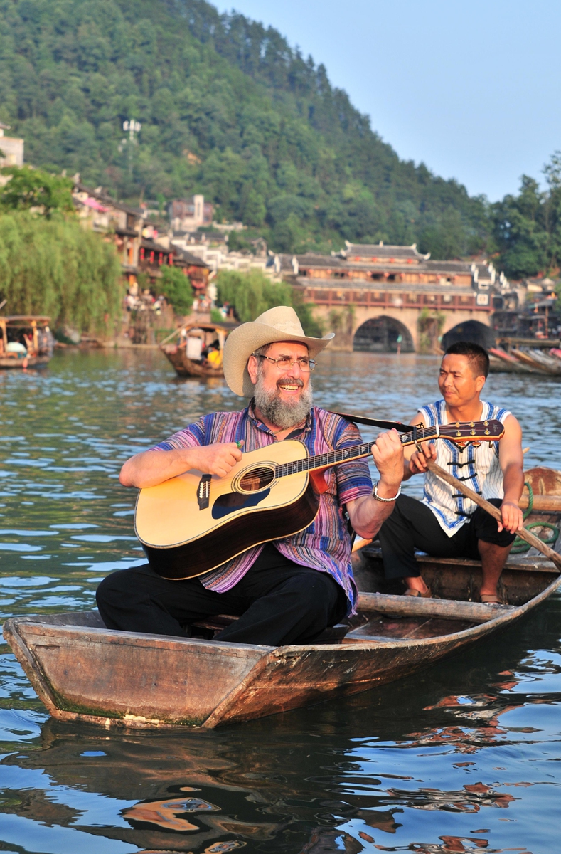 American musician Mark Levine plays the guitar while traveling along the Tuojiang River in Central China's Hunan Province. Photo: Courtesy of Levine