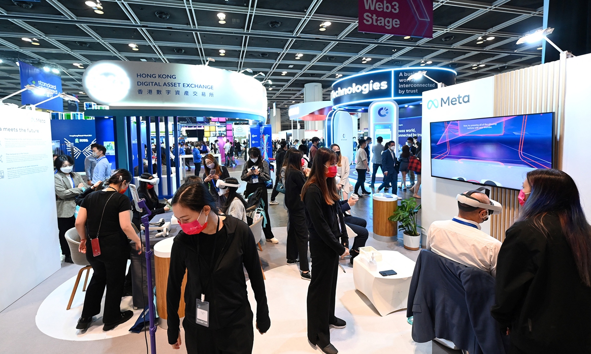Staff members help visitors using virtual reality headsets at the booth of Metaverse during Fintech Week 2022 in Hong Kong on November 1, 2022. Hong Kong hosts a week of financial conferences aimed at resuscitating the Chinese hub's image.Photo: AFP