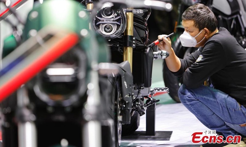 A staff member cleans a motorcycle exhibited at the automobile exhibition area of the fifth China International Import Expo (CIIE) at the National Exhibition and Convention Center in Shanghai, Nov. 7, 2022. (Photo: China News Service/Yin Liqin)

