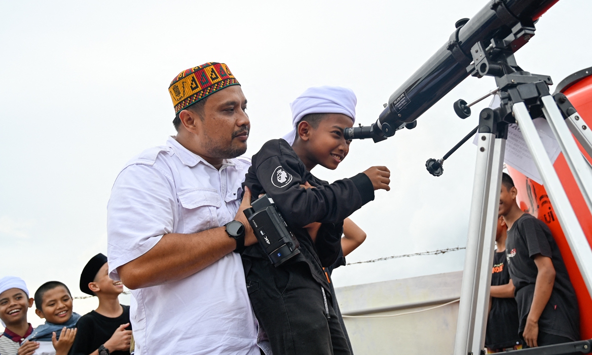 Islamic boarding school students look through telescopes as they prepare to watch a lunar eclipse in Ajun, Indonesia's Aceh Province on November 8, 2022. Nighttime skywatchers from East Asia to North America were treated to the rare spectacle of a 