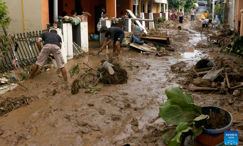 People clean mud in front of their houses after flash flood hit at Wahyu Utomo Residence in Tambakaji, Semarang, Central Java, Indonesia, Nov. 7, 2022.(Photo: Xinhua)