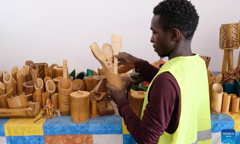 A staff member of the Uganda Bamboo Association shows bamboo products in Kampala, Uganda, Oct. 26, 2022. The Uganda Bamboo Association brings related organizations and community members together to share information, resources and technology in growing and adding value to bamboo. The association organizes demonstrations for members on how to plant bamboo and also sensitizes them about the economic benefits of the plant.(Photo: Xinhua)