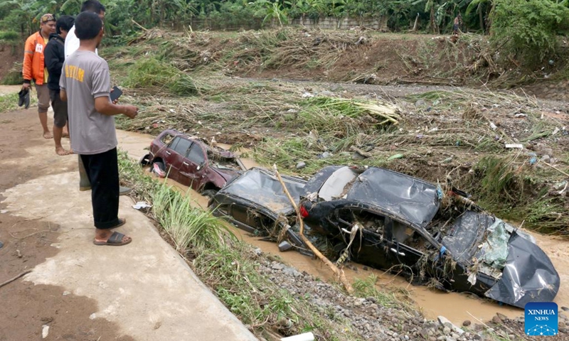 People look at damaged vehicles in a river after flash flood hit at Wahyu Utomo Residence in Tambakaji, Semarang, Central Java, Indonesia, Nov. 7, 2022.(Photo: Xinhua)