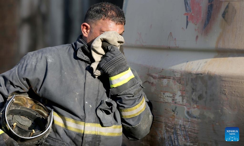 A rescuer wipes his face at the site of a building fire in central Baghdad, Iraq, on Nov. 7, 2022. Iraqi rescue teams on Monday continue to search for the 11 missing people believed to have been buried in the rubbles of a building that was engulfed by a massive fire on Sunday in central Baghdad. (Photo: Xinhua)