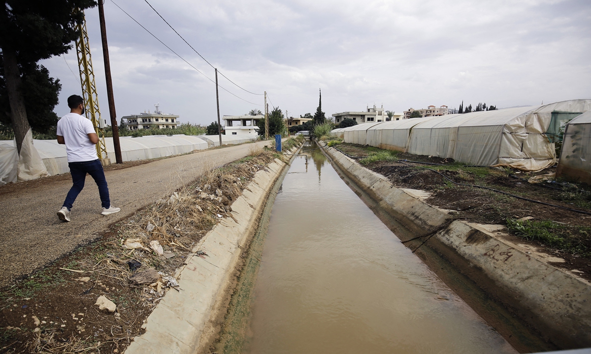 A man walks alongside a canal of contaminated water in Lebanon's cholera-stricken northern Akkar district, in late October. Photo: AFP