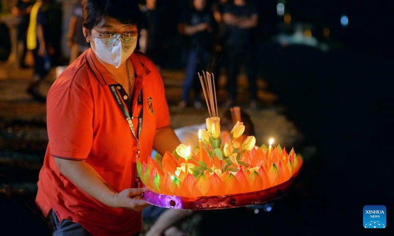 A woman prepares to release a water lantern in Bandar Seri Begawan, Brunei, on Nov. 8, 2022. The Thailand's traditional Loy Krathong Festival falls on Tuesday this year. Over 100 people including some Thai people living in Brunei released water lanterns for peace and luck.(Photo: Xinhua)