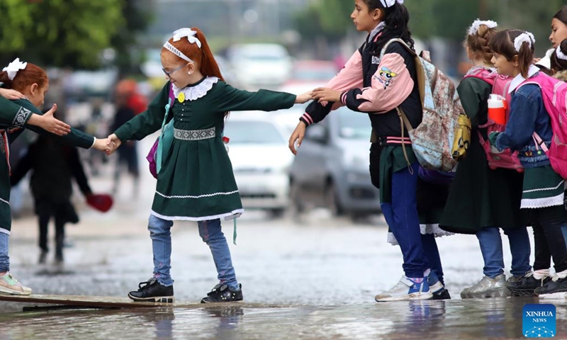 Palestinian children walk through a flooded street following heavy rain in Jabalia refugee camp in northern Gaza Strip, on Nov. 8, 2022.(Photo: Xinhua)