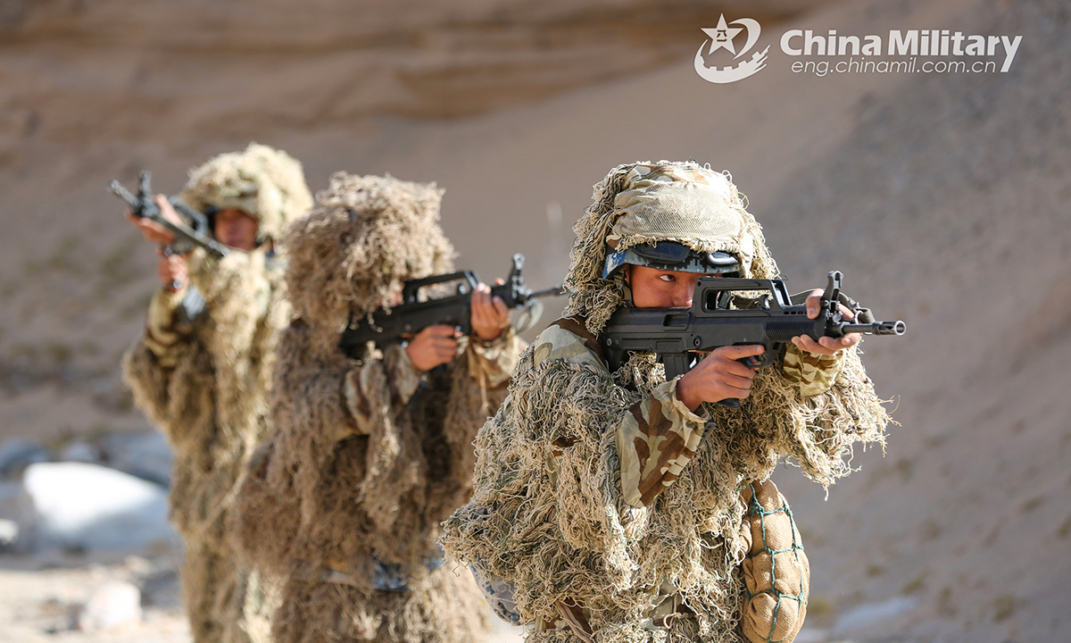 Members assigned to a reconnaissance element with an airborne brigade provide cover for each other in their ghillie suits during a tactical operation in unfamiliar terrain on October 14, 2022. (eng.chinamil.com.cn/Photo by Wang Bin)