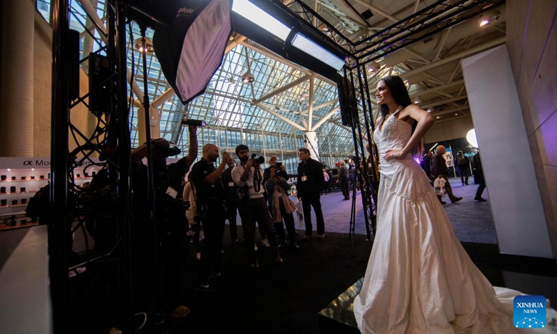 People take photos of a model during the 2022 ProFusion Expo in Toronto, Canada, on Nov. 9, 2022. The two-day photography and videography event kicked off here on Wednesday in Canada and has drawn lots of imaging professionals and enthusiasts.(Photo: Xinhua)