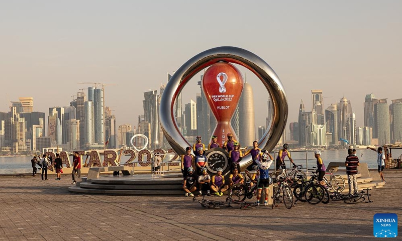 People take photos with the FIFA World Cup 2022 countdown clock near the corniche in Doha, Qatar, on Nov. 11, 2022. (Xinhua/Xu Zijian)