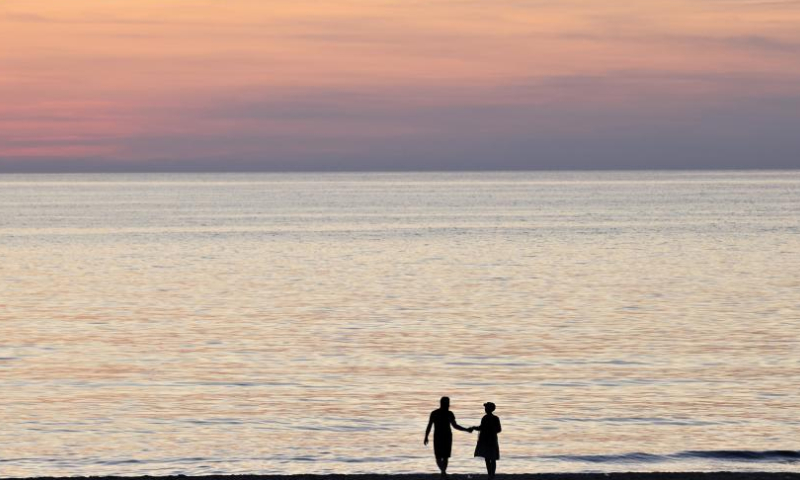 A couple enjoy themselves at sunset on the beach of the Mediterranean Sea in Beirut, Lebanon, on Nov. 20, 2022. (Xinhua/Liu Zongya)