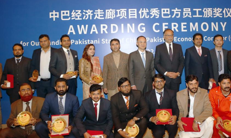 Pakistani Minister for Planning, Development and Special Initiatives Ahsan Iqbal (7th L, Rear) and Chinese Ambassador to Pakistan Nong Rong (6th L, Rear) pose for a group photo with Pakistani staff of the China-Pakistan Economic Corridor (CPEC) project at an awarding ceremony in Islamabad, Pakistan, on Dec. 30, 2022. Iqbal said on Friday that Pakistani and Chinese staff of CPEC project have joined hands to work hard with dedication as a team to make the project a success story. Photo: Xinhua