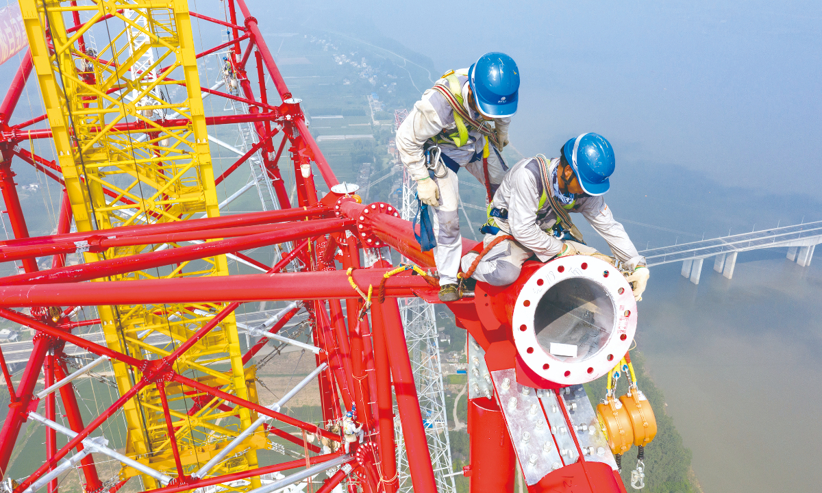 Utility technicians working at the construction site of the transmission tower of the Baihetan-Zhejiang 800-kilovolt ultra-high-voltage direct current power transmission project over the Yangtze River in Chizhou, East China’s Anhui Province on August 1, 2022. Photo: Xinhua