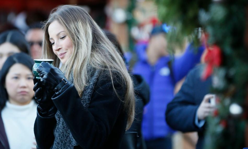 A visitor enjoys her cup of drink at the Vancouver Christmas Market in Vancouver, British Columbia, Canada, on Nov. 14, 2022. Photo: Xinhua