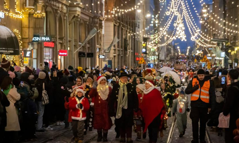 People participate in the Christmas opening celebration in Helsinki, Finland, Nov. 19, 2022. The Christmas opening celebration was held in central Helsinki on Saturday with a glittering parade, marking the start of the festive season. (Photo by Matti Matikainen/Xinhua)