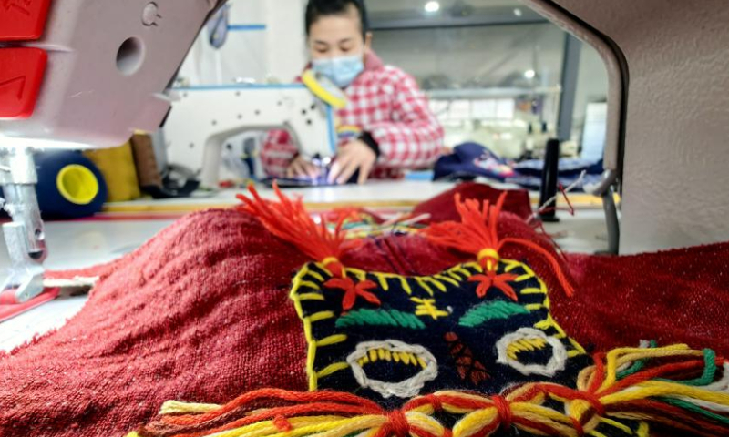 A woman makes traditional Chinese cloth shoes at a factory in Heze, east China's Shandong Province, Dec.1, 2022. (Photo: China News Service/Gao Yuhua) Handmade shoes, like Tiger Shoes for children, gained popularity these years in Shandong.
