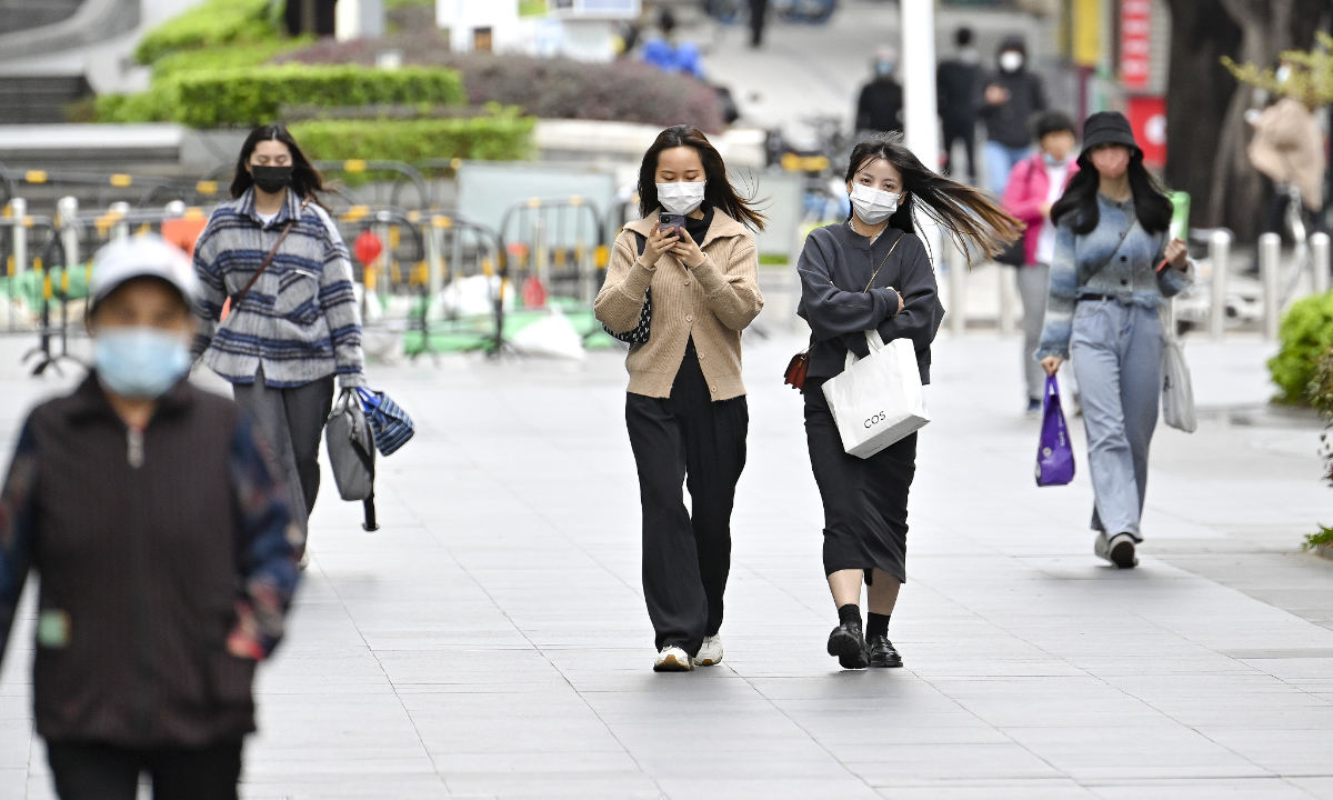 Residents wearing face masks on a street in Guangzhou in South China’s Guangdong Province on Thursday. Several districts in Guangzhou have lifted temporary restrictions. Photo: VCG

