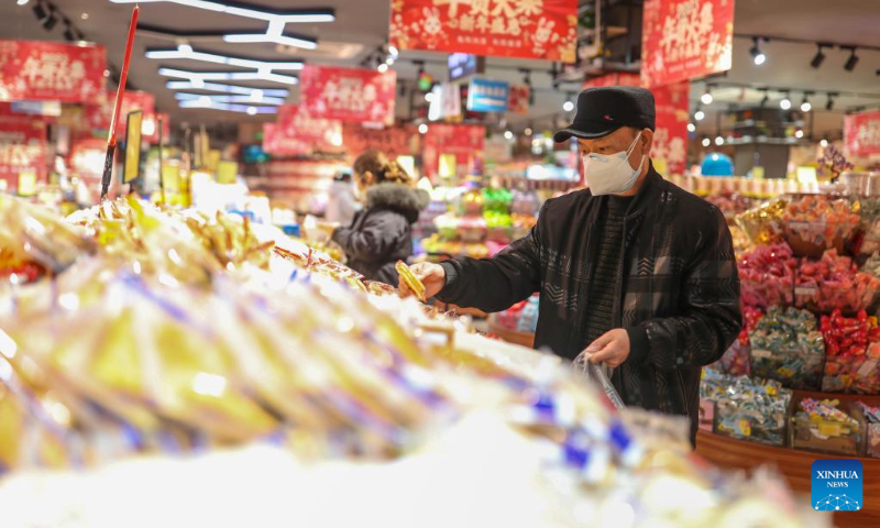 People select goods at a supermarket in Yuping Dong Autonomous County of Tongren City, southwest China's Guizhou Province, Jan. 1, 2023. (Photo by Hu Panxue/Xinhua)