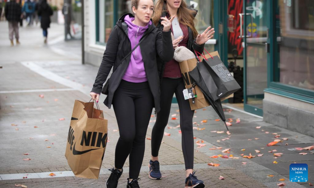 People walk with shopping bags during Black Friday in Vancouver, British Columbia, Canada, on Nov 25, 2022. Photo:Xinhua