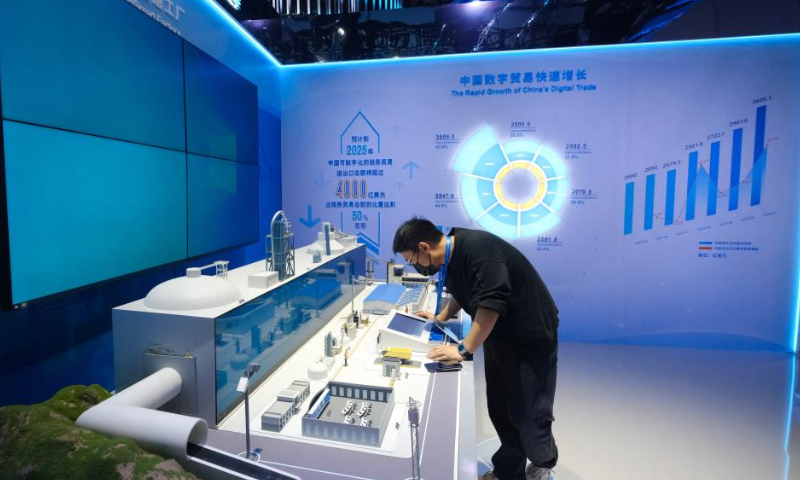 A staff member checks a model of 5G+ Smart Factory at the first Global Digital Trade Expo in Hangzhou, east China's Zhejiang Province, Dec. 11, 2022.

The 4-day expo kicked off here on Sunday. Around 800 leading digital trade companies from China and abroad will showcase their new products and technologies during the expo. (Xinhua/Xu Yu)