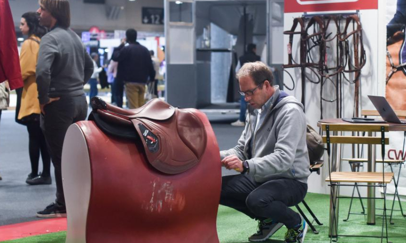 Visitors view exhibits at an exhibition during the IFEMA Madrid Horse Week in Madrid, Spain, Nov. 25, 2022. (Photo by Gustavo Valiente/Xinhua)